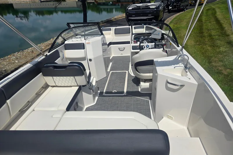 Slide: The Image of 2020 Bayliner DX 2250 boat interior with seating, steering wheel, and sink. - 10