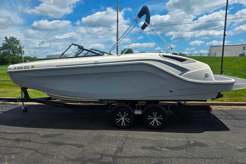 Slide: The Image of 2020 Bayliner DX 2250 boat on trailer under a blue sky with clouds. - 4