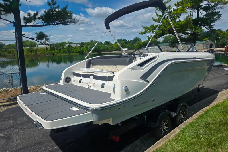 Slide: The Image of 2020 Bayliner DX 2250 boat on trailer by a scenic lake. - 1