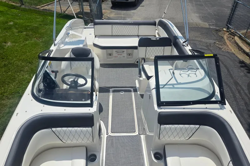 Slide: The Image of 2020 Bayliner DX 2250 boat interior with seating, steering wheel, and open deck layout. - 21