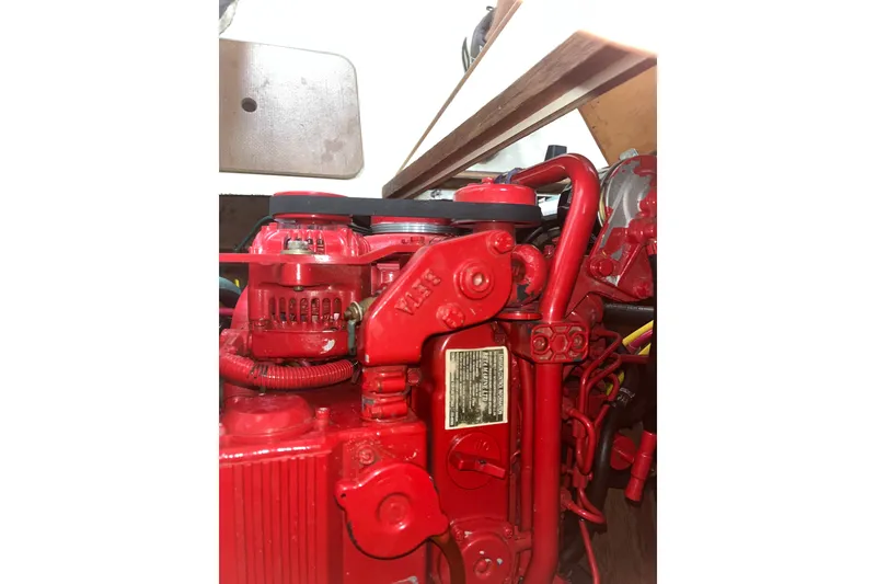 Slide: The Image of Red engine inside a 1976 Pearson 10M sailboat, showcasing detailed mechanical components. - 32
