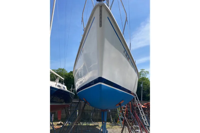 Slide: The Image of 1976 Pearson 10M sailboat on stands, blue hull, sunny day. - 34