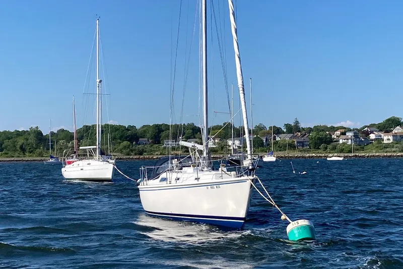 Slide: The Image of 1976 Pearson 10M sailboat moored on a sunny day, coastal background. - 36