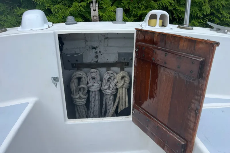 Slide: The Image of Open wooden hatch on 1976 Pearson 10M sailboat, revealing neatly coiled ropes inside. - 20