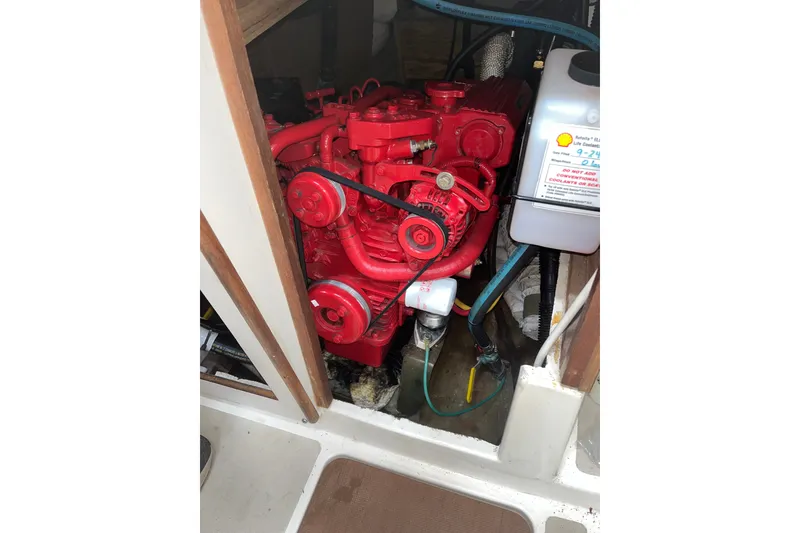 Slide: The Image of Red engine inside a 1976 Pearson 10M sailboat, showcasing mechanical components. - 33