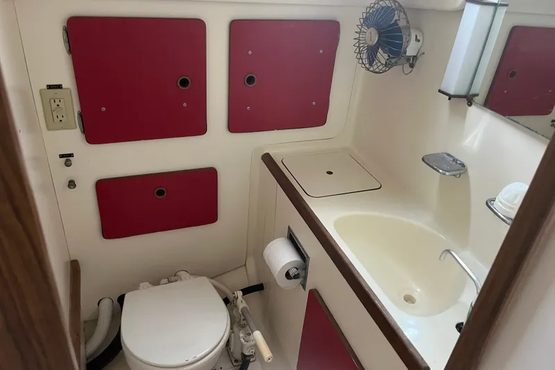 Slide: The Image of 1976 Pearson 10M yacht bathroom with sink, toilet, and storage compartments. - 30
