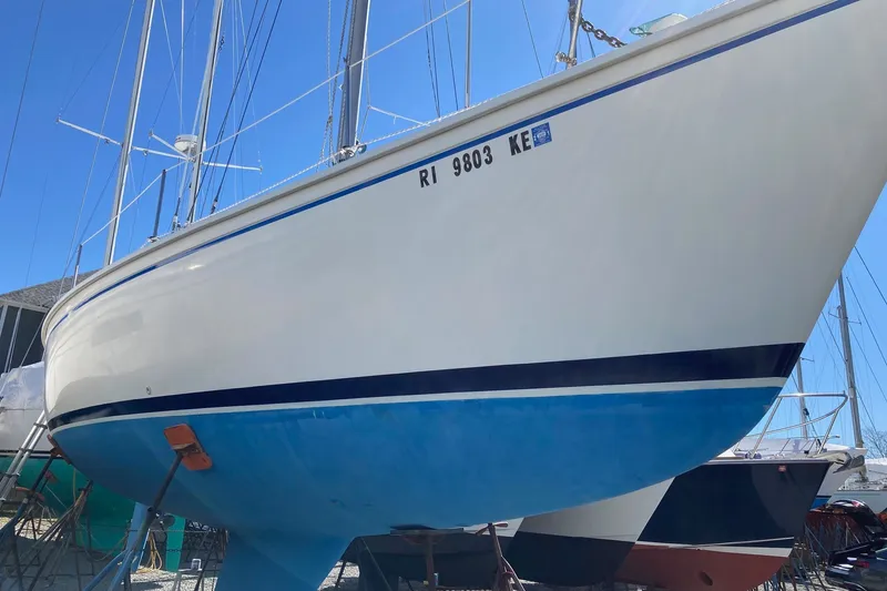 Slide: The Image of 1976 Pearson 10M sailboat with blue hull, docked on land under clear sky. - 35
