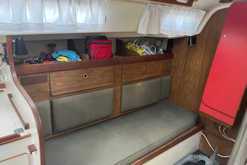 Slide: The Image of Cozy interior of a 1976 Pearson 10M sailboat with storage and seating. - 28