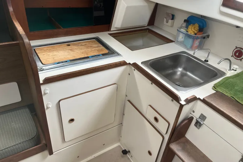 Slide: The Image of 1976 Pearson 10M yacht kitchen with sink, cutting board, and storage cabinets. - 23