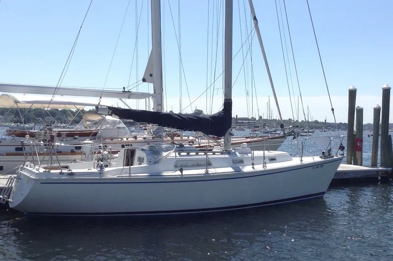 The Image of 1976 Pearson 10M sailboat docked at marina, clear sky, calm water. - 0