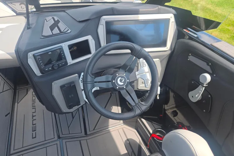 Slide: The Image of 2025 Centurion Nv233 boat dashboard with steering wheel and modern controls. - 26