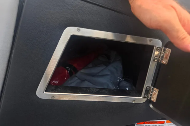 Slide: The Image of Storage compartment in a 2025 Centurion Nv233 boat, partially open with visible contents. - 27