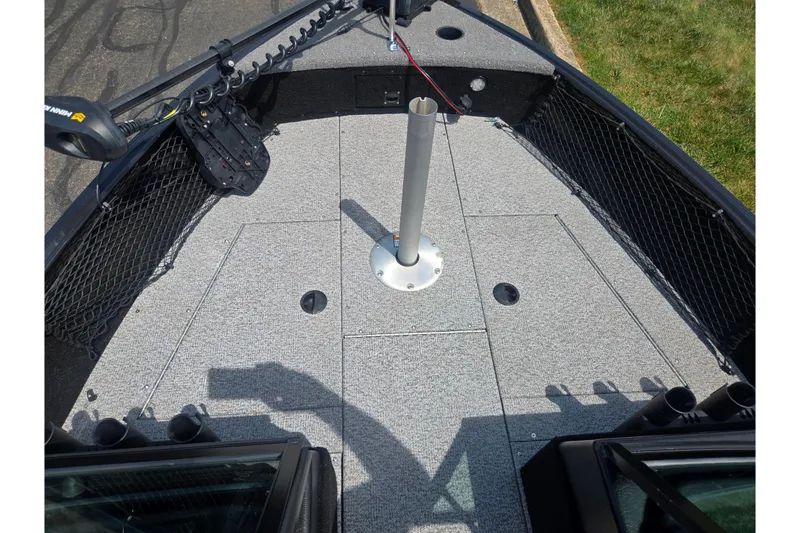 Slide: The Image of 2023 Alumacraft Competitor 165 Sport boat deck with fishing rod holders and storage compartments. - 16