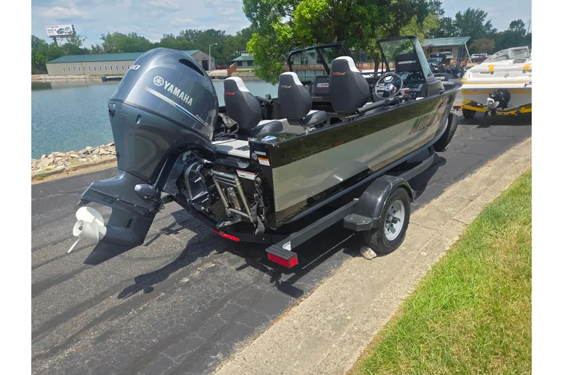 Slide: The Image of 2023 Alumacraft Competitor 165 Sport boat with Yamaha motor on trailer by a lake. - 1
