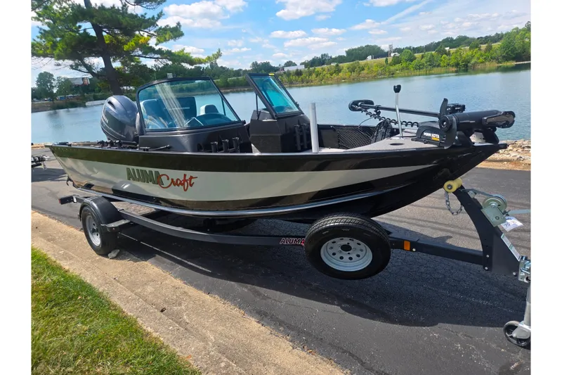 Slide: The Image of 2023 Alumacraft Competitor 165 Sport boat on trailer by a scenic lake. - 9