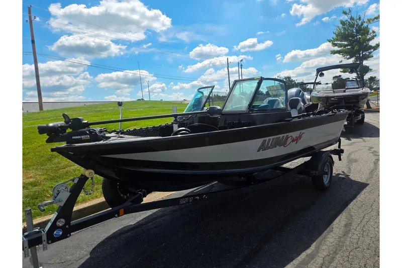 Slide: The Image of 2023 Alumacraft Competitor 165 Sport boat on trailer under a sunny sky. - 6
