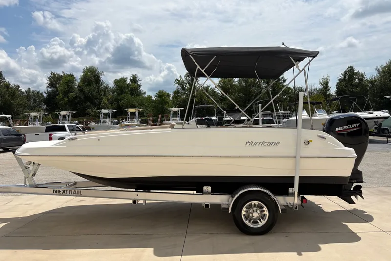 Slide: The Image of 2022 Hurricane SunDeck Sport 201 OB boat on trailer, parked outdoors under cloudy sky. - 5