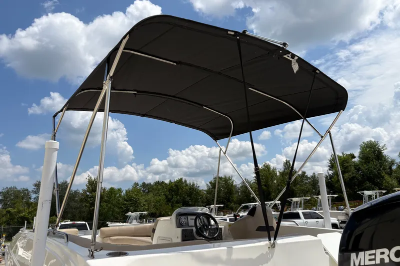 Slide: The Image of 2022 Hurricane SunDeck Sport 201 OB boat with canopy under a cloudy sky. - 17