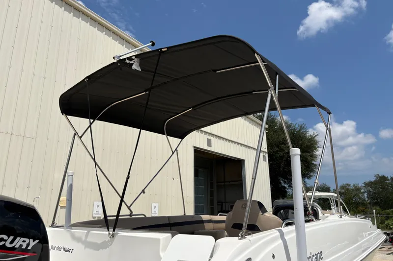 Slide: The Image of 2022 Hurricane SunDeck Sport 201 OB boat with canopy, parked outdoors. - 15