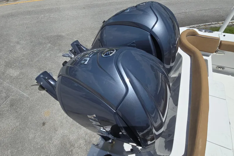 Slide: The Image of Twin outboard motors on a 2023 Sea Hunt Ultra 275SE boat, parked on pavement. - 21
