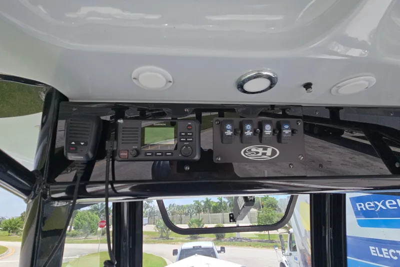 Slide: The Image of 2023 Sea Hunt Ultra 275SE boat dashboard with Garmin radio and control panel. - 24