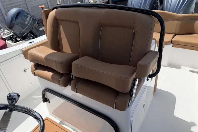 Slide: The Image of 2023 Sea Hunt Ultra 275SE boat with brown cushioned seating and steering wheel. - 15