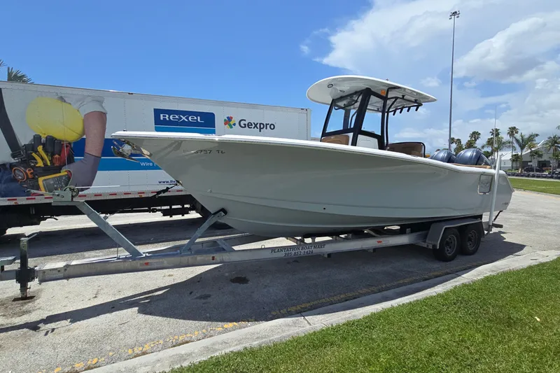 The Image of 2023 Sea Hunt Ultra 275SE boat on trailer, parked outdoors under blue sky. - 0