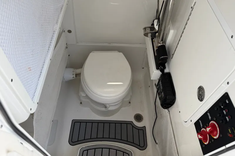 Slide: The Image of 2023 Sea Hunt Ultra 275SE boat interior with marine toilet and control panel. - 14