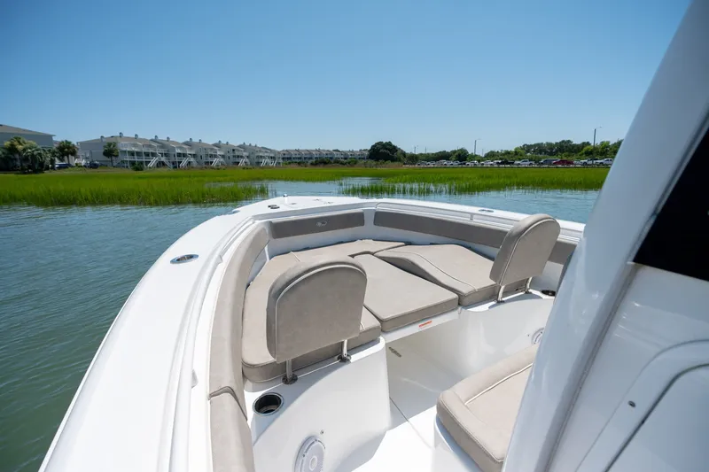 Slide: The Image of 2024 Sea Hunt Ultra 265SE boat interior with comfortable seating on calm water. - 8