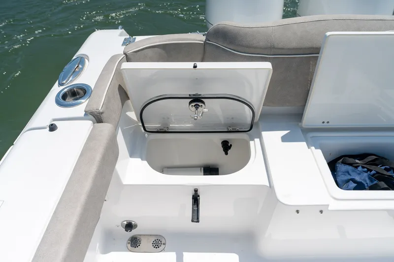Slide: The Image of 2024 Sea Hunt Ultra 265SE boat storage compartment with open hatch, showing interior details. - 34