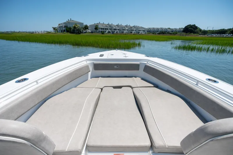 Slide: The Image of 2024 Sea Hunt Ultra 265SE boat with spacious bow seating, overlooking serene waterfront scenery. - 9