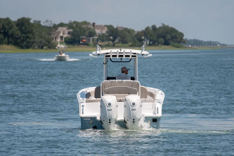 Slide: The Image of 2024 Sea Hunt Ultra 265SE boat cruising on a serene waterway. - 3