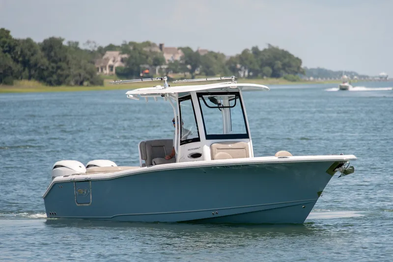 Slide: The Image of 2024 Sea Hunt Ultra 265SE boat cruising on a serene lake with scenic background. - 6