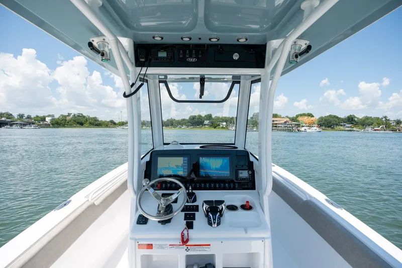 Slide: The Image of 2024 Sea Hunt Ultra 265SE boat dashboard with navigation screens on a sunny day. - 17