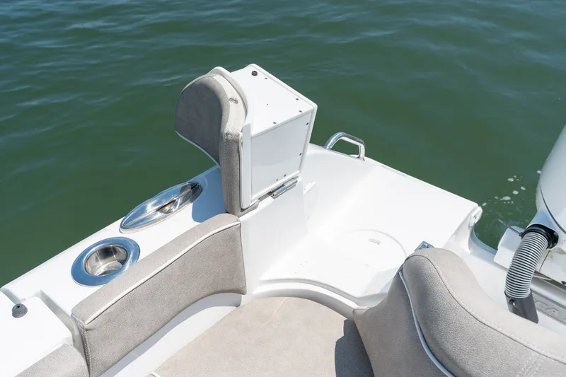 Slide: The Image of 2024 Sea Hunt Ultra 265SE boat interior with seating and cup holders on water. - 27