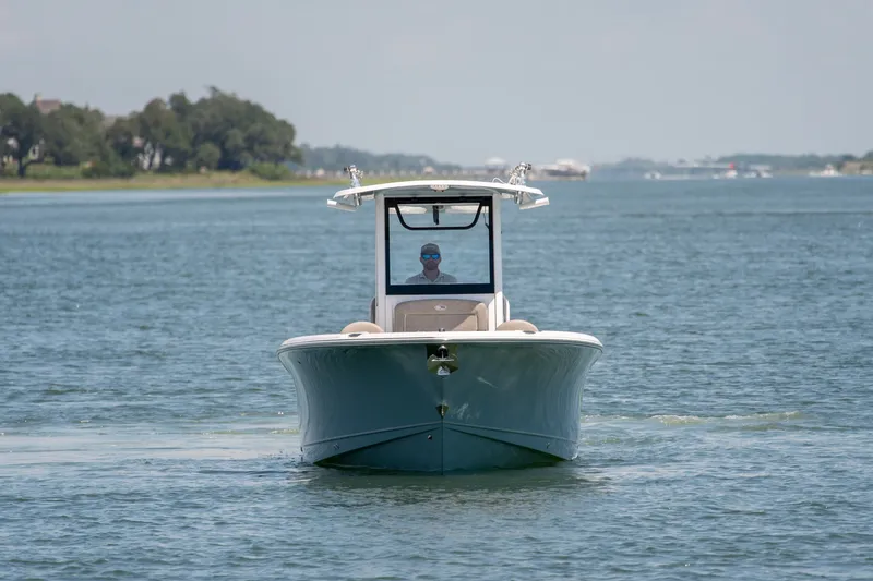 Slide: The Image of 2024 Sea Hunt Ultra 265SE boat cruising on a calm waterway. - 7