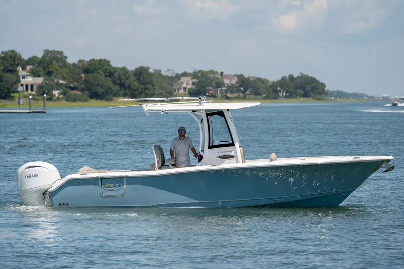 Slide: The Image of 2024 Sea Hunt Ultra 265SE boat cruising on a scenic waterway. - 5