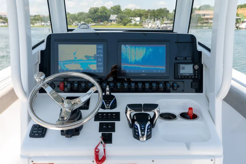 Slide: The Image of 2024 Sea Hunt Ultra 265SE boat dashboard with navigation screens and controls. - 18