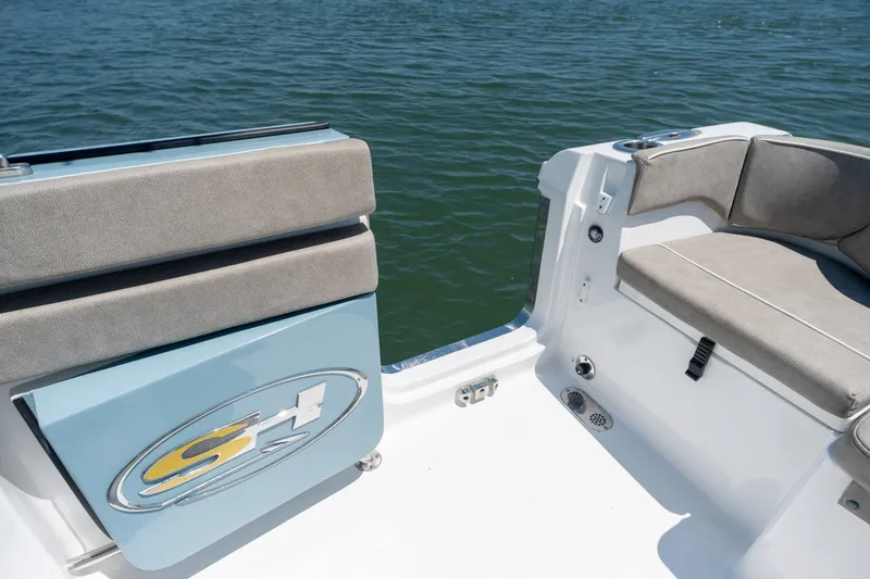 Slide: The Image of 2024 Sea Hunt Ultra 265SE boat interior with cushioned seating by the water. - 28