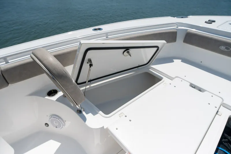 Slide: The Image of 2024 Sea Hunt Ultra 265SE boat storage compartment open on deck. - 12