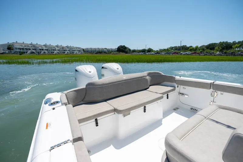 Slide: The Image of 2024 Sea Hunt Ultra 265SE boat with spacious seating, cruising on a scenic waterway. - 24