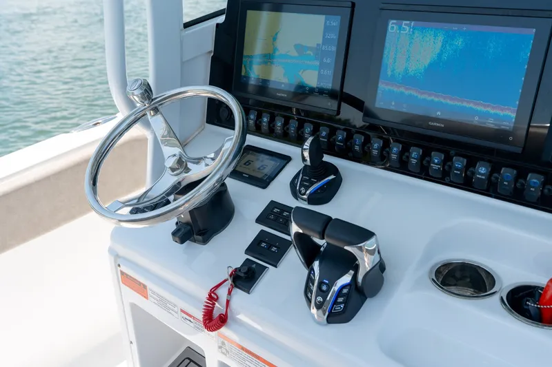 Slide: The Image of 2024 Sea Hunt Ultra 265SE boat dashboard with steering wheel and navigation screens. - 19