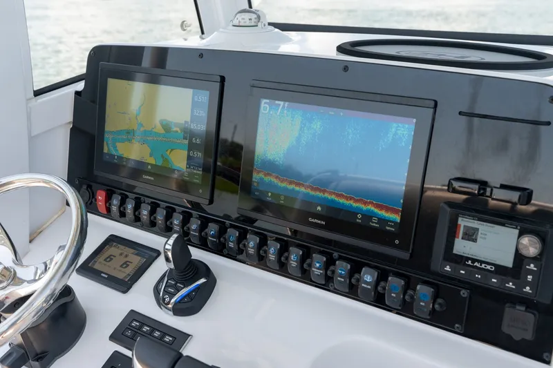 Slide: The Image of 2024 Sea Hunt Ultra 265SE dashboard with Garmin displays and JL Audio system. - 20