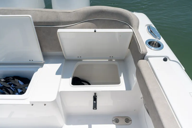 Slide: The Image of 2024 Sea Hunt Ultra 265SE boat storage compartments with cup holder, open on deck. - 36