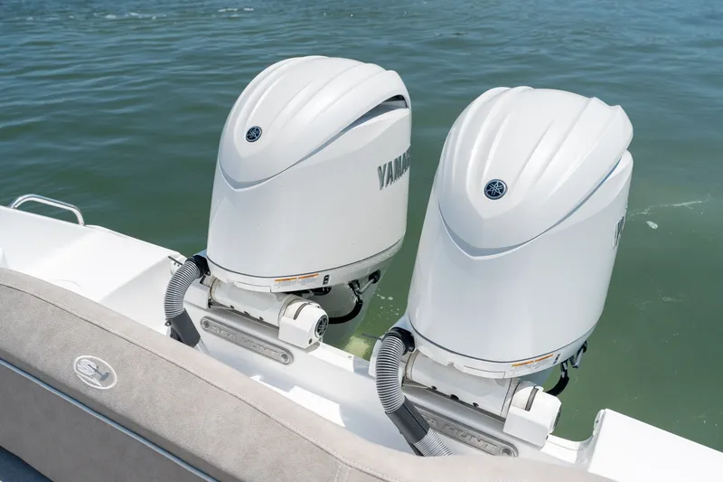 Slide: The Image of 2024 Sea Hunt Ultra 265SE boat with dual Yamaha outboard engines on water. - 26
