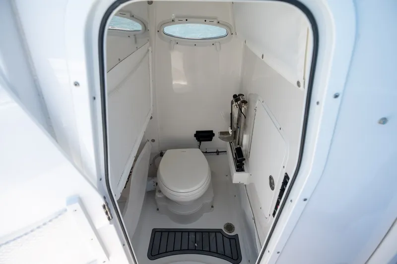 Slide: The Image of 2024 Sea Hunt Ultra 265SE boat interior with compact marine toilet. - 14