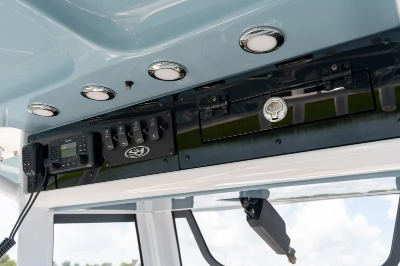 Slide: The Image of 2024 Sea Hunt Ultra 265SE boat console with controls and radio equipment. - 21