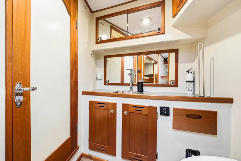 Slide: The Image of Compact yacht bathroom with wooden cabinetry, mirrors, and modern fixtures, Dixon 55, 2018 model. - 44