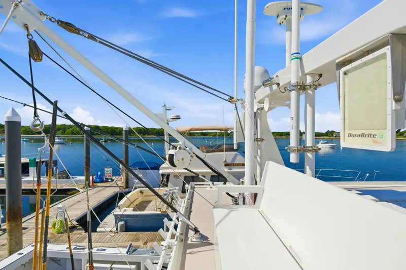 Slide: The Image of Modern Dixon 55 yacht docked at marina, showcasing advanced equipment and serene waterfront view. - 21