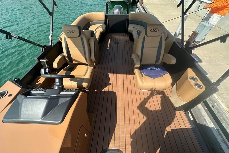 Slide: The Image of 2026 Bentley Pontoons Legacy 243 Navigator interior with luxurious seating and wood-style flooring. - 2